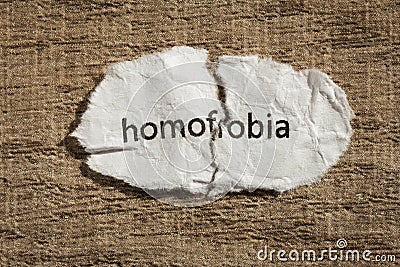 Torn paper written homofobia, portuguese and spanish word for ho Stock Photo