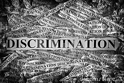 Torn pieces of paper with the word Discrimination Stock Photo