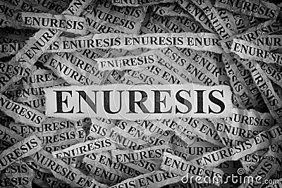 Torn pieces of paper with the words Enuresis Stock Photo