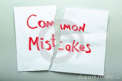Torn sheet of paper with text COMMON MISTAKES on light background Stock Photo