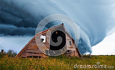 Tornado forming behind old barn Stock Photo