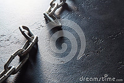 Torned up chain on dark textured background, place for text. Broken metal chain, copy space. Freedom, liberty concept Stock Photo