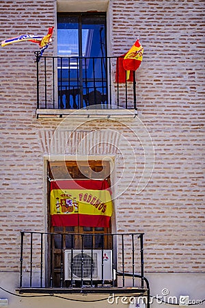 Facade of a house, with numerous flags of Spain Editorial Stock Photo