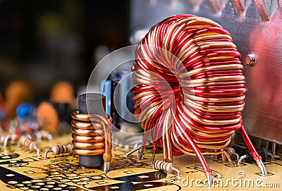 Inductor copper wire winding. Electronic components soldered in circuit board Stock Photo