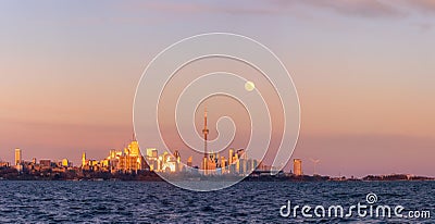 Beautiful soft pink colors at dusk with the full moon rising over the Toronto skyline and CN Tower Editorial Stock Photo