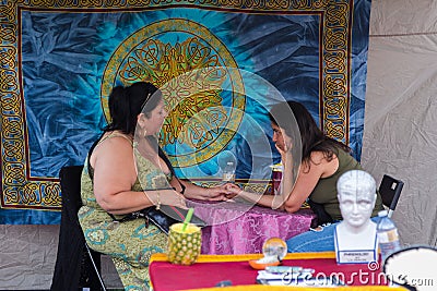 TORONTO, ON, CANADA - JULY 29, 2018: A fortune teller with a client at Kensington market in Toronto. Editorial Stock Photo