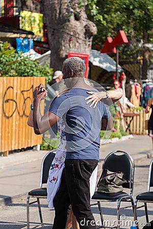 TORONTO, ON, CANADA - JULY 29, 2018: An interracial couple dancing in the street at Kensington market in Toronto. Editorial Stock Photo