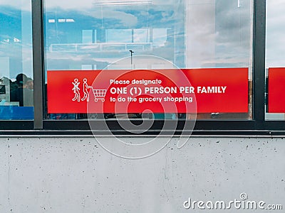 Toronto, Ontario, Canada - August 16, 2020: Warning notice sign on store market window to designate one person per family to do Editorial Stock Photo