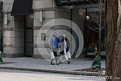 Toronto, Ontario, Canada - March 21 2023 - Couple walks down the street in deep conversation Editorial Stock Photo