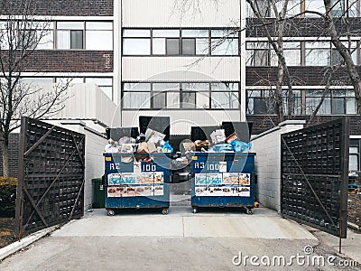 Toronto, Ontario, Canada - March 08, 2020: Litter garbage large blue bins standing outdoors by residential condo building Editorial Stock Photo