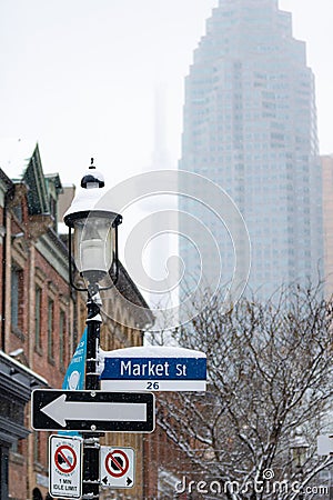 Toronto, Ontario - December 2, 2019 : Market Street sign with the CN Tower seen behind St. Lawrence Market on a cloudy foggy day. Editorial Stock Photo