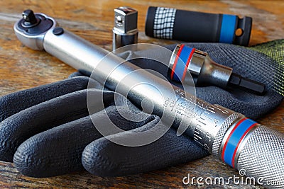 Torque wrench with spanner heads and work glove on the table in a workshop Stock Photo