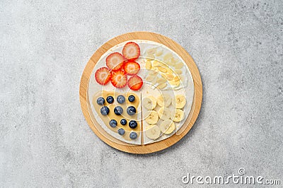 Tortilla cooking with different fillings of peanut butter, banana, strawberry, blueberry, almond. Food trend Stock Photo