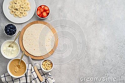 Tortilla cooking process with different fillings of peanut butter, banana, strawberry, blueberry, almond. Food trend Stock Photo