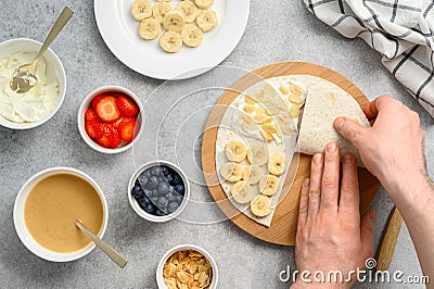 Tortilla cooking process with different fillings of peanut butter, banana, strawberry, blueberry, almond. Food trend Stock Photo