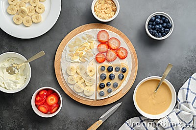 Tortilla cooking process with different fillings of peanut butter, banana, strawberry, blueberry, almond. Food trend Stock Photo