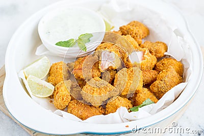 Tortilla crusted baked fish bites on white bowl Stock Photo