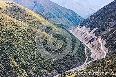 Tortuous mountain road in the green valley Stock Photo