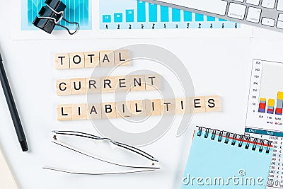 Total current liabilities concept with letters on cubes Stock Photo