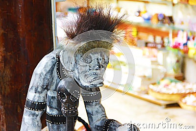 Totem figure, wooden sculpture of a scary monster with ornament tattoos Editorial Stock Photo