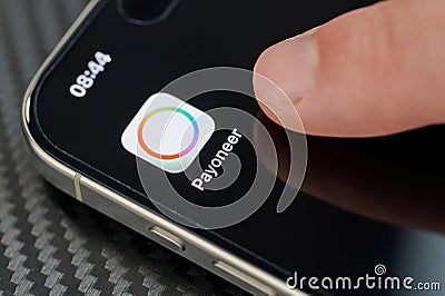Touching Payoneer app icon with finger Editorial Stock Photo