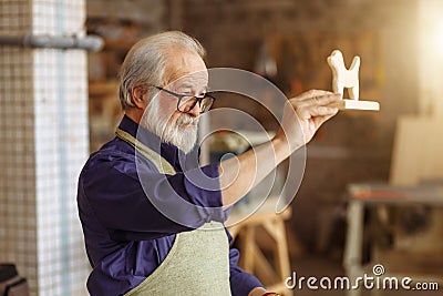 Touching tribute for kids. senior citizen has created gift from natural wood Stock Photo