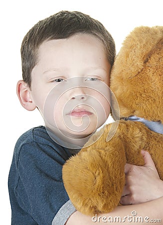 Tough boy cuddling bear Stock Photo