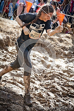 Tough Mudder: Young Female Racer Running through the Electric Obsticle Editorial Stock Photo