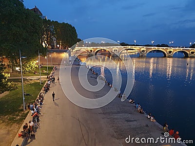 Young people on the banks of the river and enjoying the heat of the late summer in a beautiful environment. Editorial Stock Photo