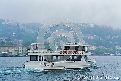 Tour boat on Bosphorus strait on rainy spring day Istanbul city Turkey Editorial Stock Photo