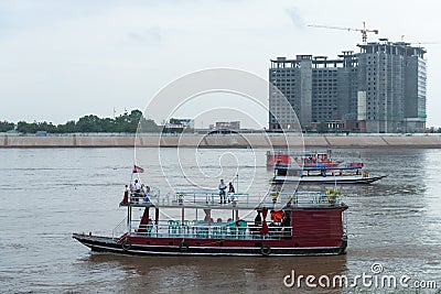 Tour boats on the Tonle Sap River, with the Sokha Hotel under co Editorial Stock Photo