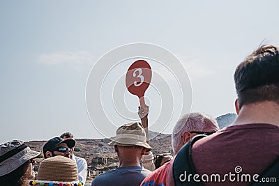 Tour guide holding group number up on the island of Delos, Greece Editorial Stock Photo