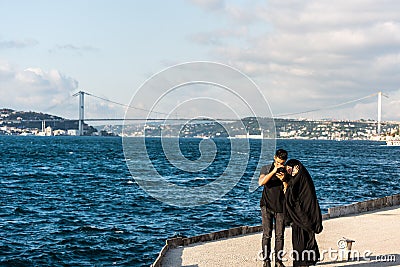 A tourish couple taking pictures at the Corniche park at Uskudar, Istanbul, Turkey, on the Anatolian shore of the Bosphorus Editorial Stock Photo