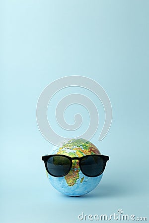 Tourism, ecology, vacation and globalism concept. Globe in sunglasses on a blue background banner. Minimal creative Stock Photo