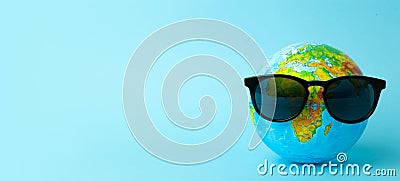 Tourism, ecology, vacation and globalism concept. Globe in sunglasses on a blue background banner. Minimal creative Stock Photo