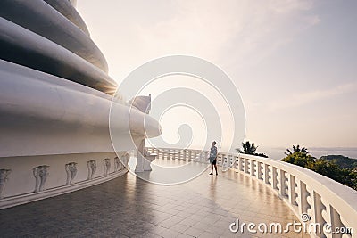 Tourist admiring Peace Pagoda against ocean at sunset Stock Photo