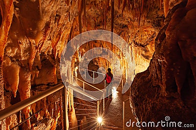 Tourist admiring the stalactites in limestone cave. Stock Photo