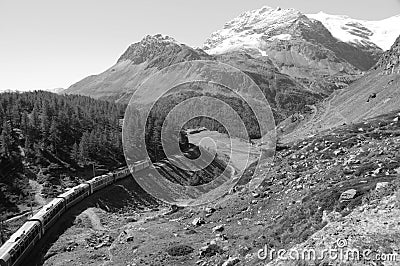 Tourist attraction Bernina train in the Swiss Alps near Alp GrÃ¼m Stock Photo