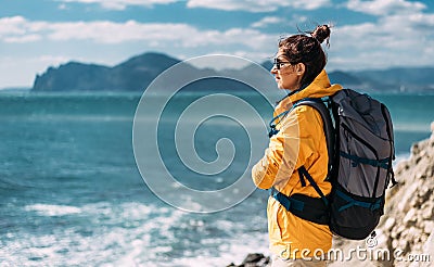 Tourist with a backpack against the sea, panorama. Portrait of a woman in tourist gear against the sea. Travel Stock Photo