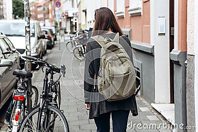Tourist with a backpack is looking for booked online accommodation in an unfamiliar city. Stock Photo