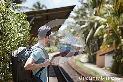 Tourist with backpack waiting on railroad platform Stock Photo