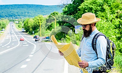 Tourist backpacker looks at map choosing travel destination at road. Around the world. Find map large sheet of paper Stock Photo