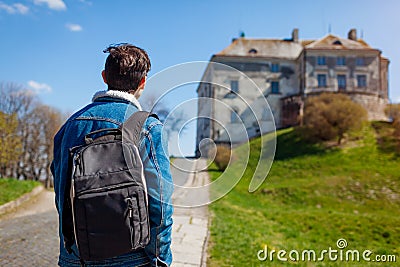 Tourist backpacker visiting Olesko Castle in spring. Trip to Western Ukraine. Traveler enjoys landscape Stock Photo