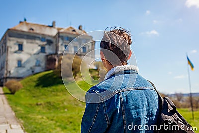 Tourist backpacker visiting Olesko Castle in spring. Trip to Western Ukraine. Traveler man enjoys architecture Stock Photo