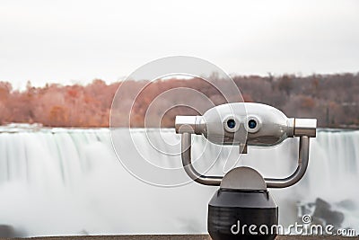 Tourist Binocular with a Waterfall in Background at Sunset Stock Photo