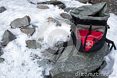 Tourist black backpack lying at snow and stone Stock Photo