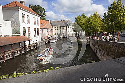 Tourist boat in bruges canal near old bridge on sunny summer day Editorial Stock Photo