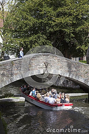 Tourist boat in bruges canal under old bridge on sunny summer da Editorial Stock Photo