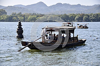 Tourist Boat near a Floating Stone Pagoda on The West Lake. Hangzhou, Zhejiang, China. October 28, 2018. Editorial Stock Photo