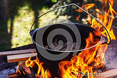 Tourist bowler with food on bonfire, cooking in the hike, outdoor activities. Preparation of pilaf. Stock Photo